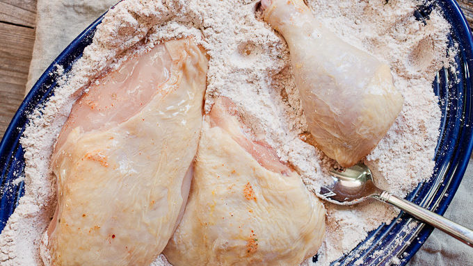 Raw chicken dipped in flour mixture