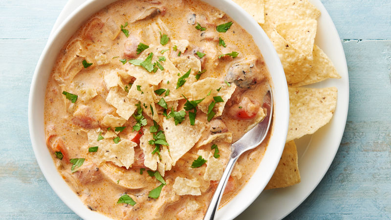 Slow-Cooker King Ranch Chicken Soup prepared recipe in a bowl with corn chips on the side